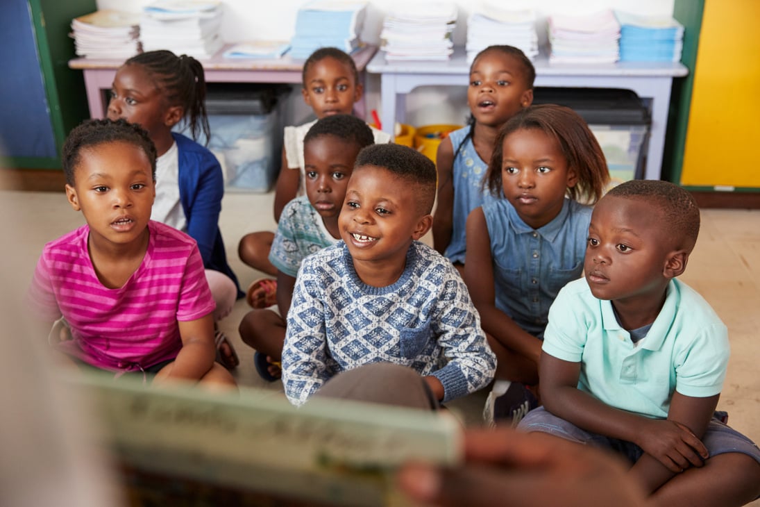 Teacher Reading Book to Elementary School Children